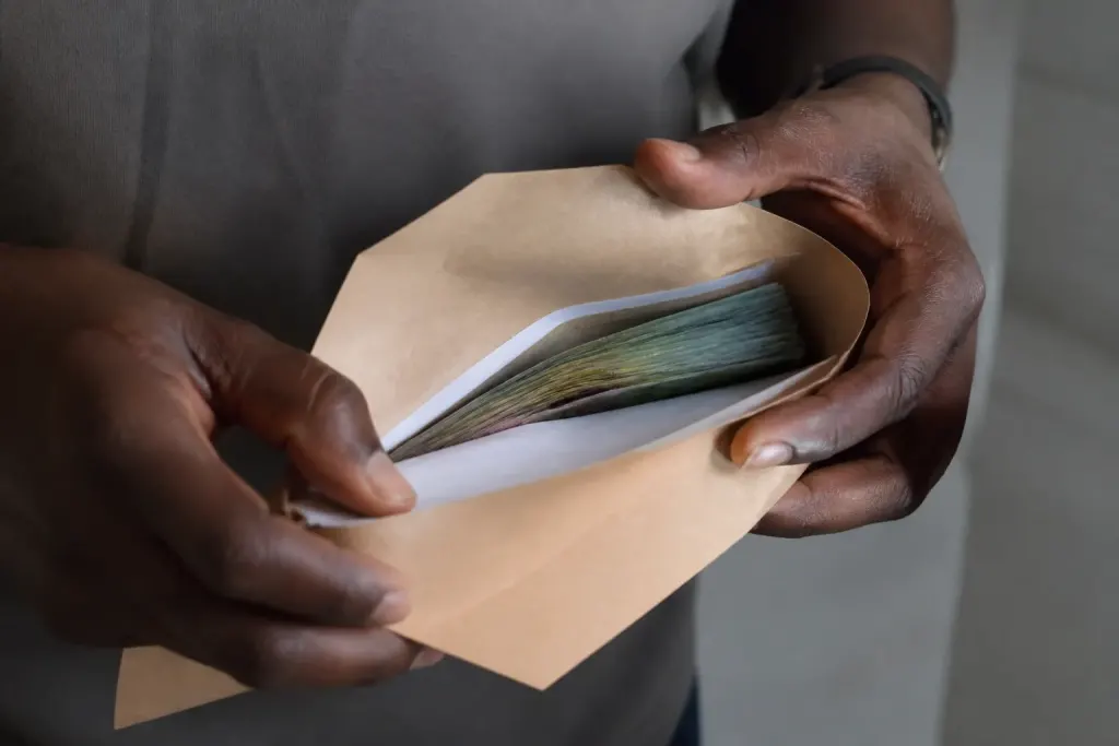 Enveloppe contenant documents financiers et billets de banque.