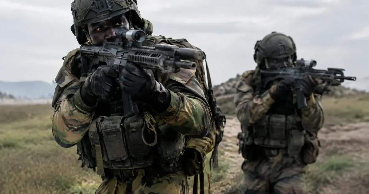 Soldats noirs equipement lourd debout armes pointees